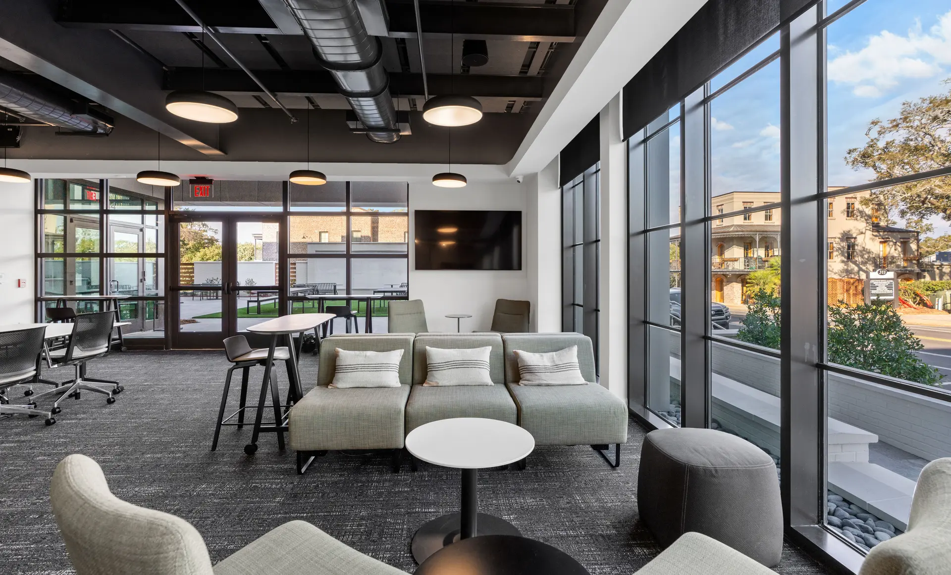 Lounge and meeting area at Magnolia with a presentation display and street-facing windows